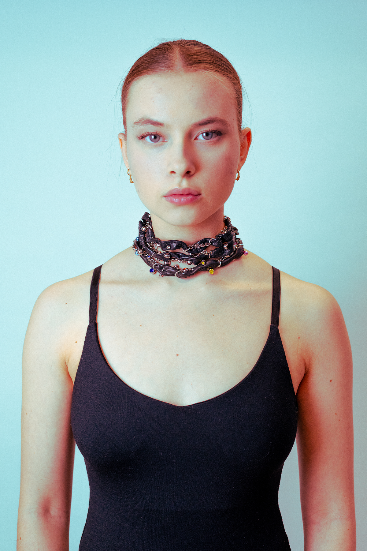 the model wears three pierced necklaces in black